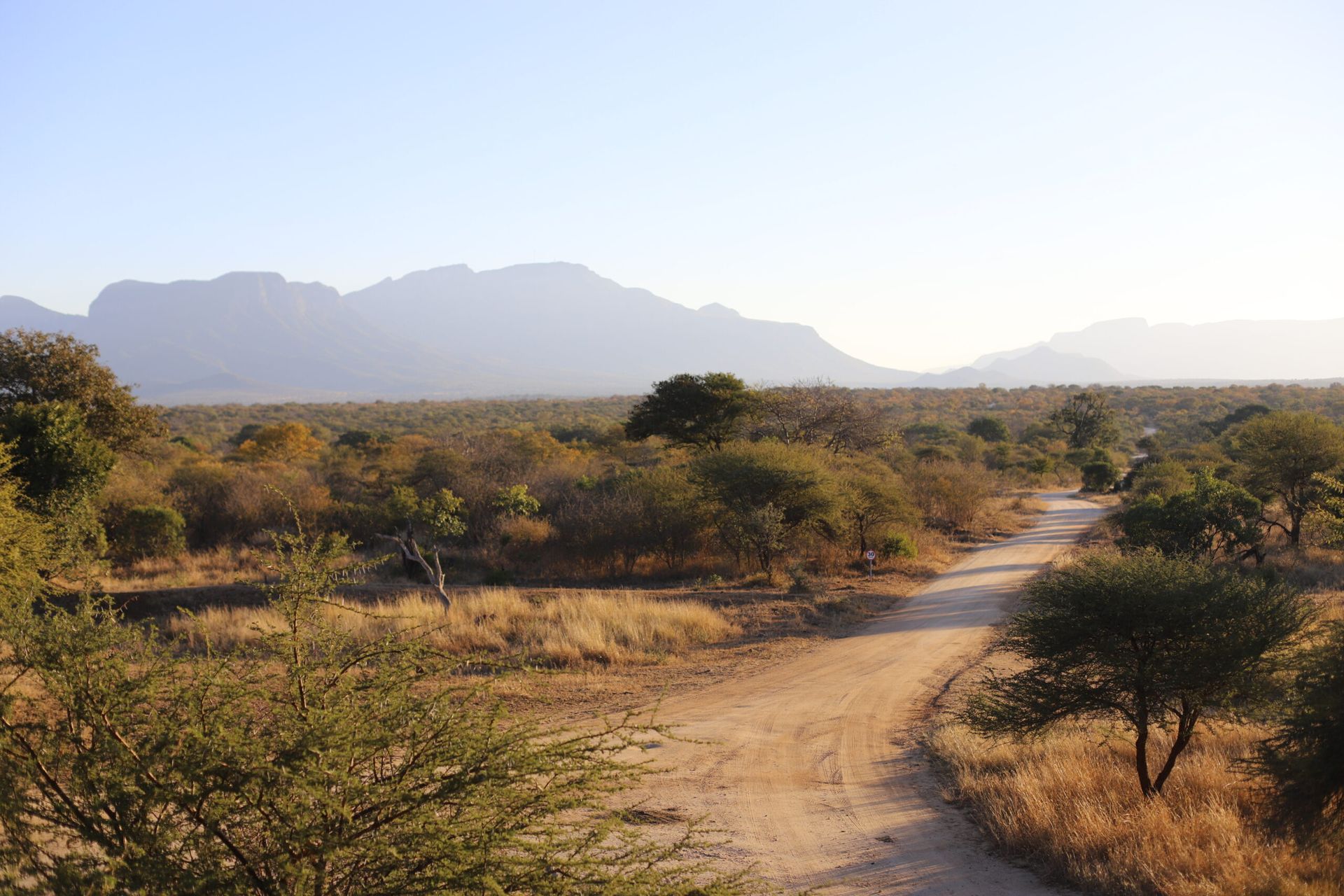 a dirt road with mountains in the background